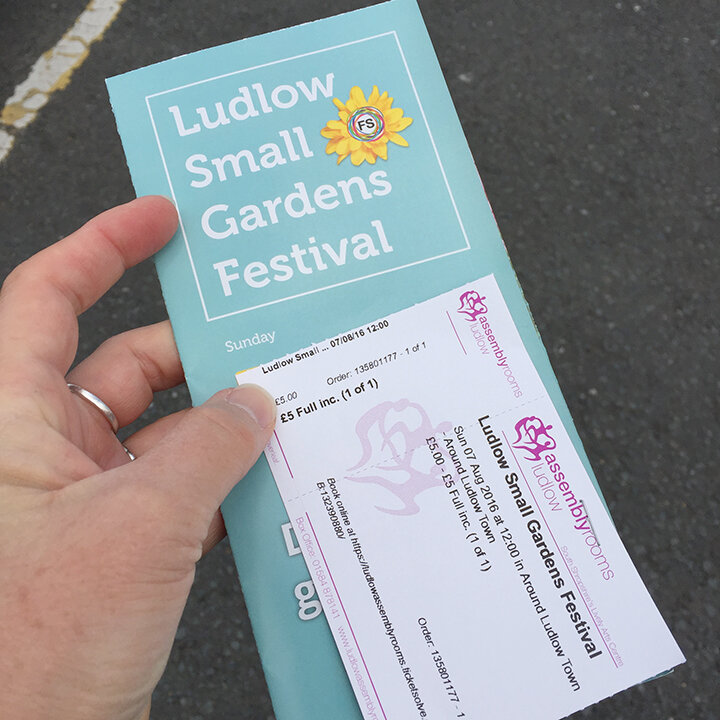 Photo of hand holding brochure and ticket for a garden tour.Tours are a fun way for the solo traveler to meet people