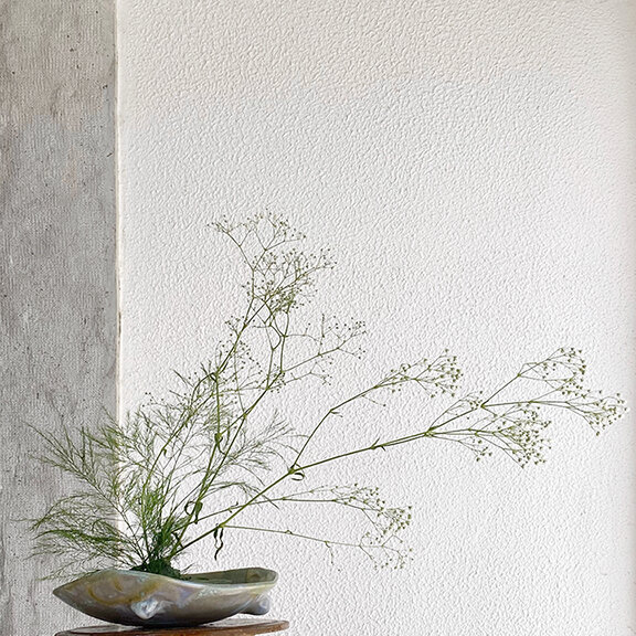 delicate green branches, tiny white flowers. flat vase, flower design