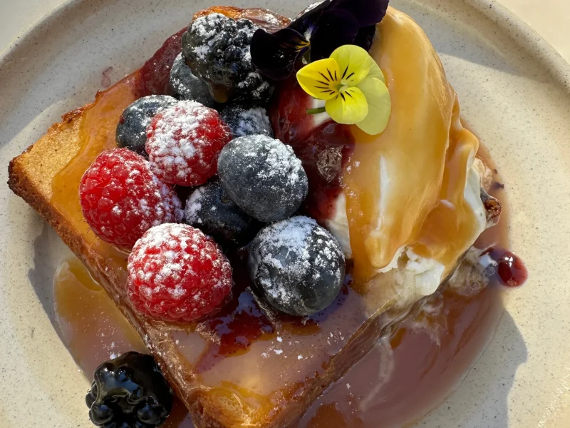 Magnolia waffle has raspberries, mascarpone cheese, caramel and blue berries