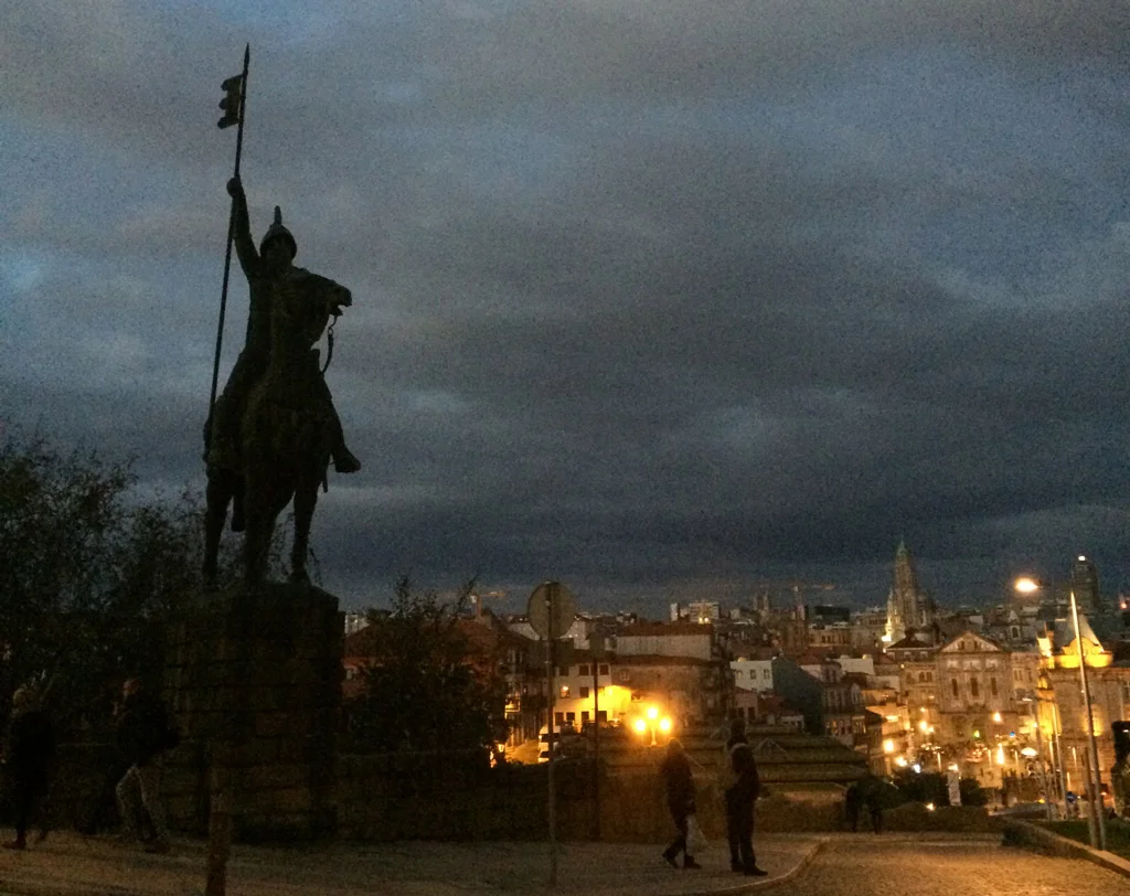 statue of soldier on horse, night photo, city lights to the right, Porto, Portugal