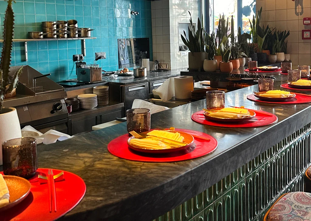 interior with counter top, red placemats , yellow knapkings, blue /green wall