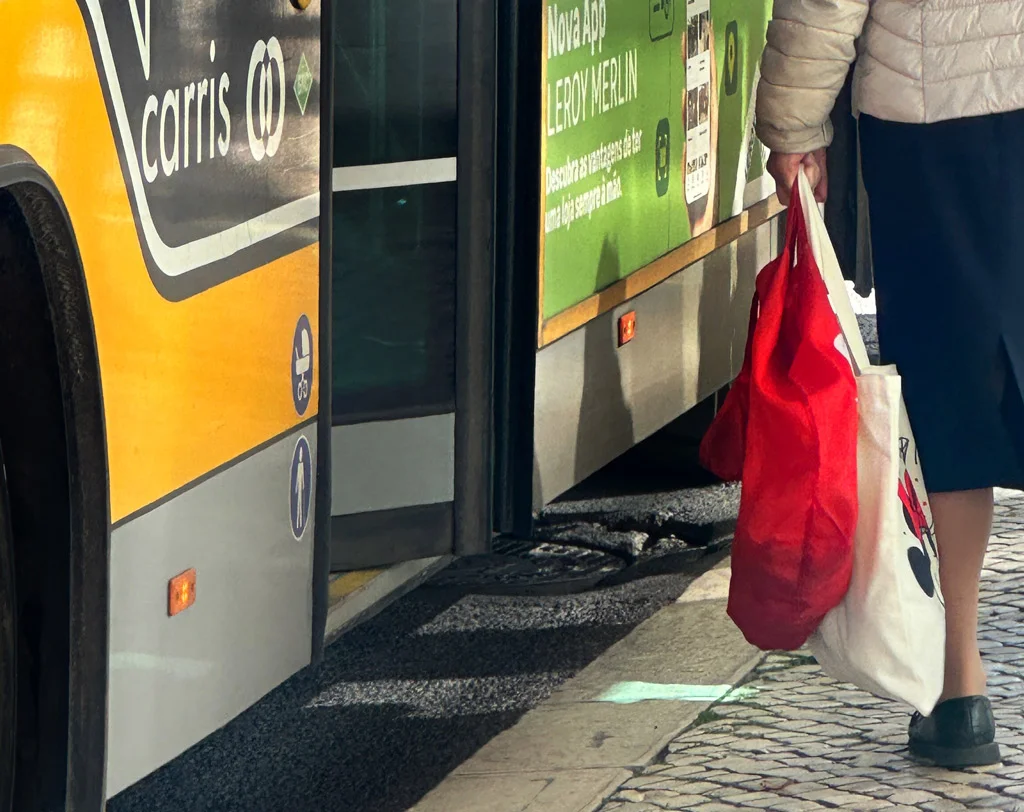 part of a person holding red shopping bag, green on bus, yellow on bus