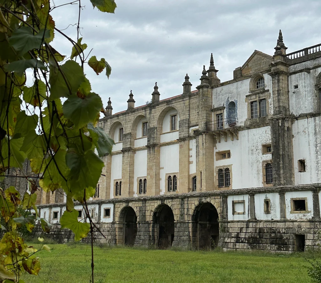 convent of Tomar, tree on left and bright grass, dark skies