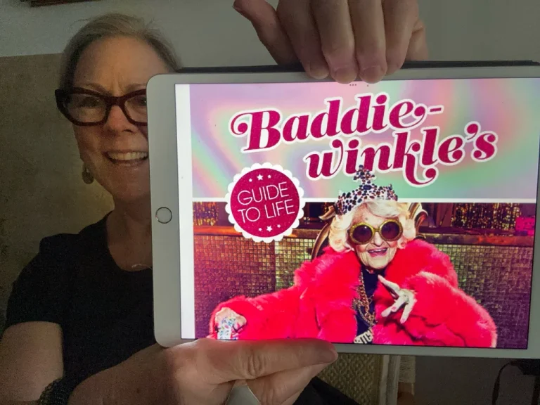 woman holding up her ipad with a copy of Baddiewinkle book cover