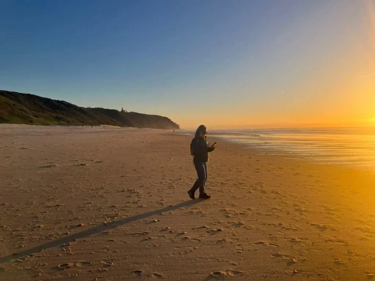 photo of a person on the beach during the sunset
