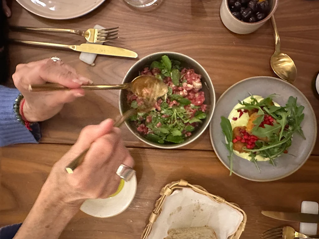 hand holds a spoon to serve a dish