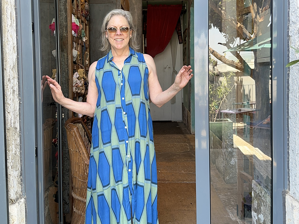 woman standing at door, blue dress, summer travel photography