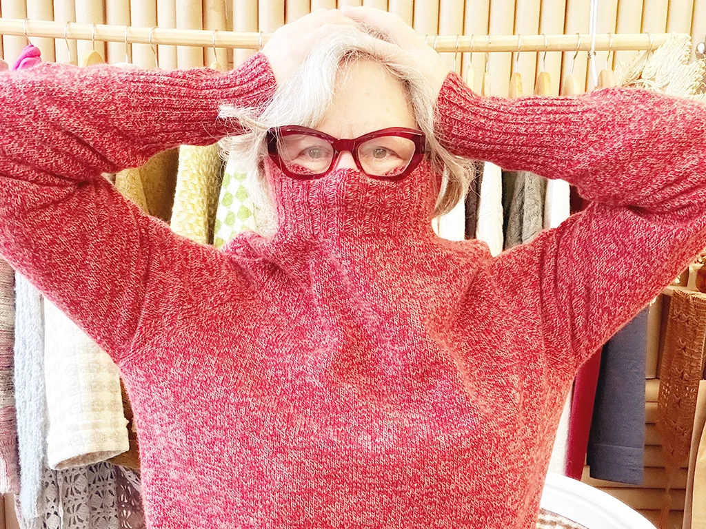 woman wearing a red turtle neck sweater that covers part of her face