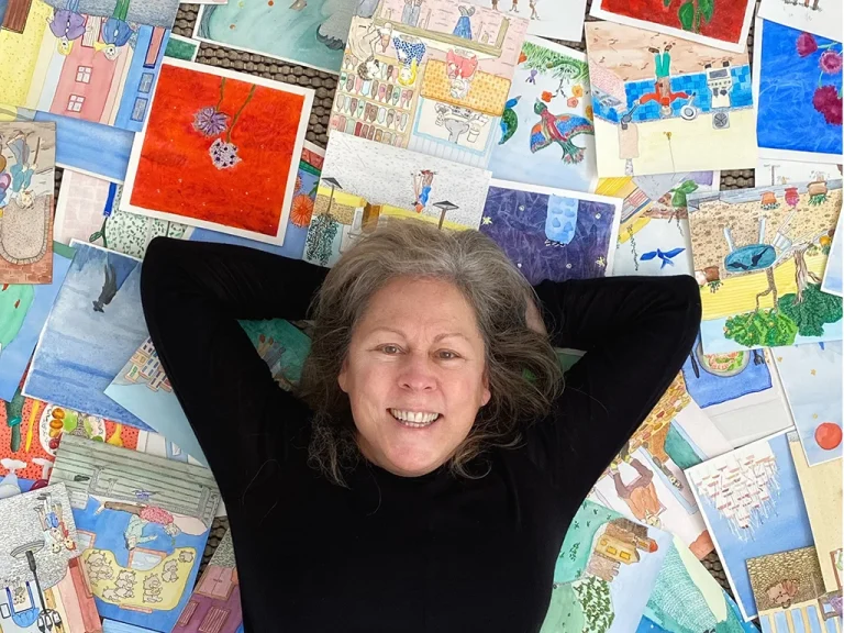 woman lying on floor over many watercolour paintings, almost 70